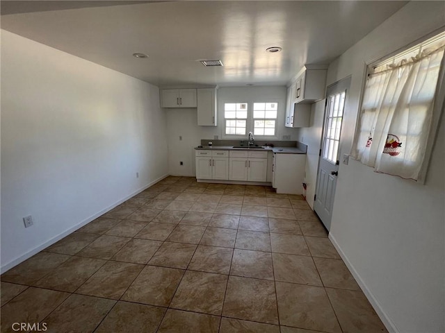 kitchen featuring white cabinetry, sink, and light tile patterned floors