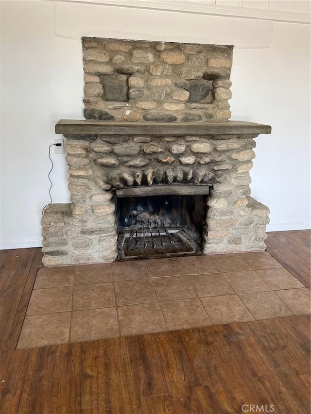 details with wood-type flooring and a stone fireplace