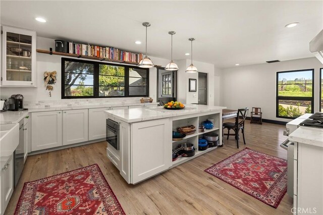 kitchen featuring a healthy amount of sunlight, light wood-type flooring, and white cabinetry