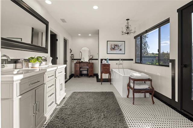 bathroom featuring a bathtub, an inviting chandelier, and vanity