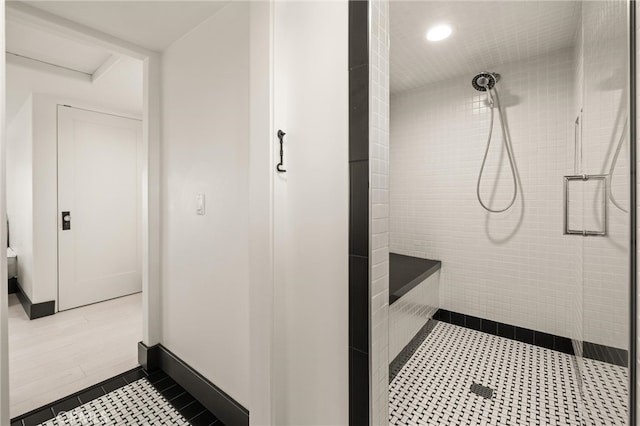 bathroom with a tile shower and tile flooring