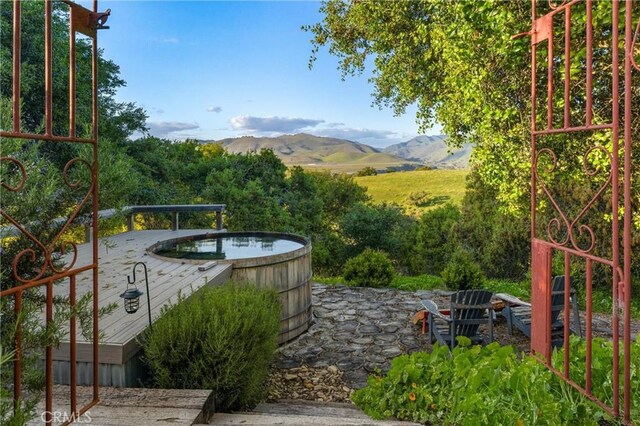 view of patio / terrace with a mountain view and a hot tub