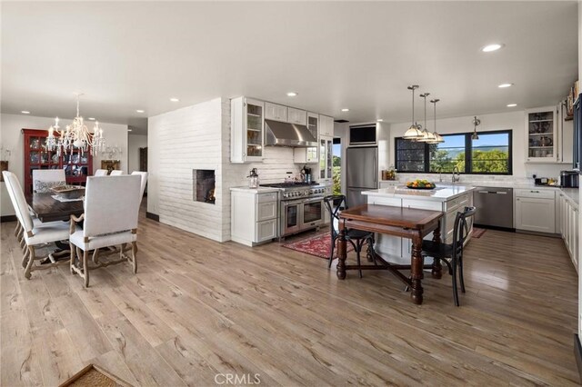 interior space with a large fireplace, sink, a chandelier, and hardwood / wood-style flooring