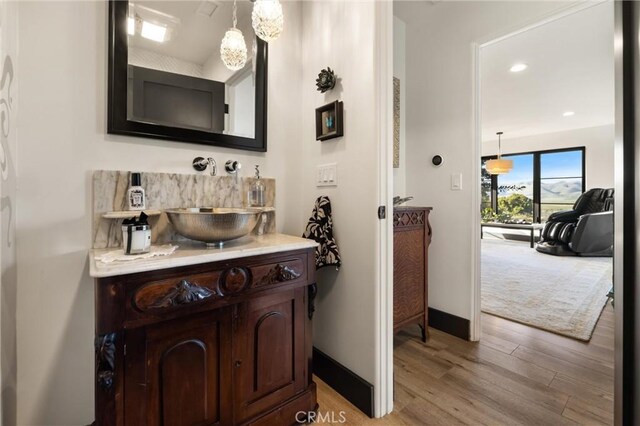 bathroom with wood-type flooring and large vanity