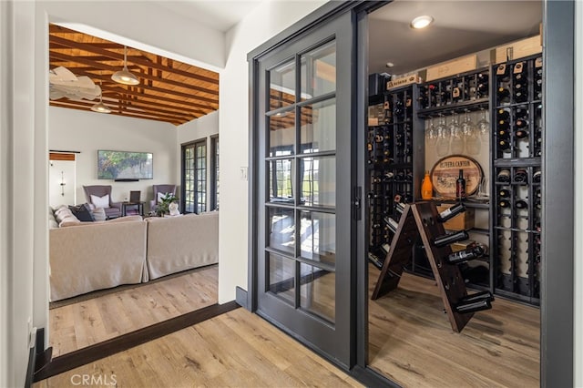 wine room with vaulted ceiling and hardwood / wood-style floors