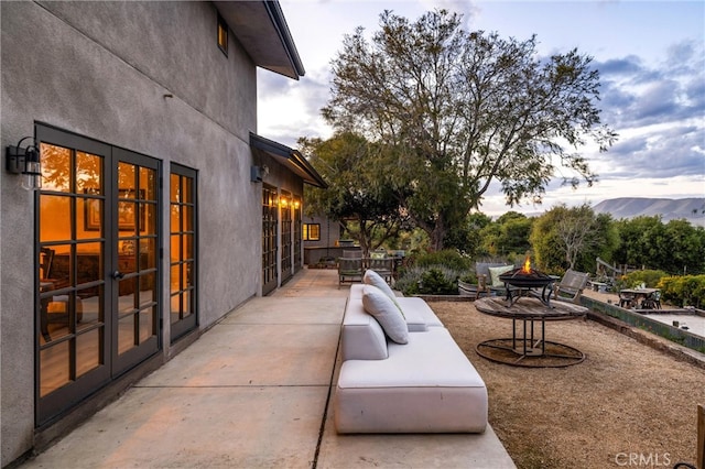 view of patio / terrace with a fire pit and a mountain view