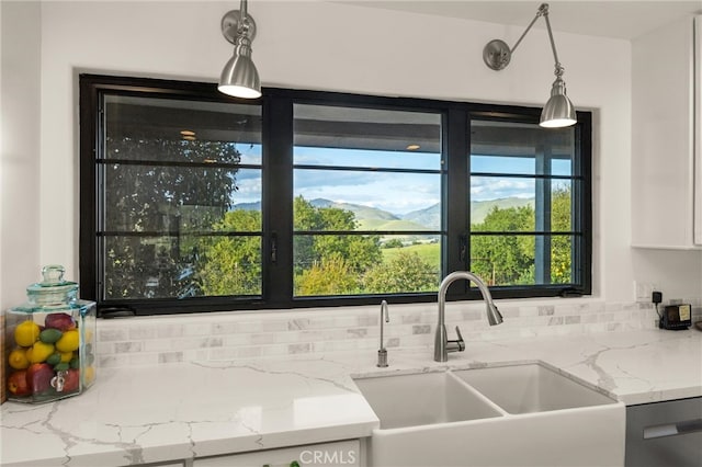 kitchen featuring sink, tasteful backsplash, dishwashing machine, and pendant lighting