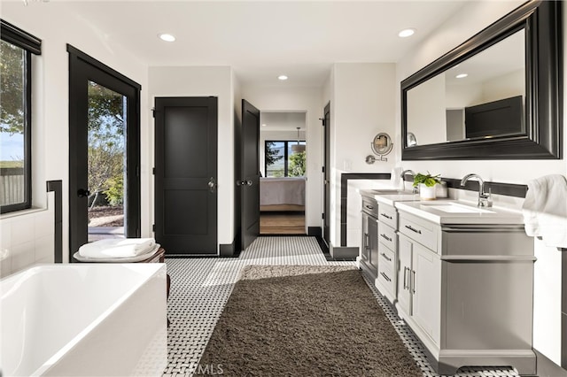 bathroom with a bath, tile flooring, and double sink vanity