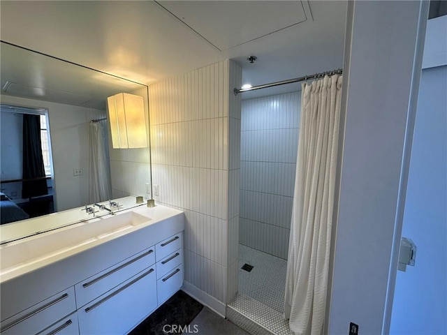 bathroom with a shower with shower curtain, vanity, and tile walls