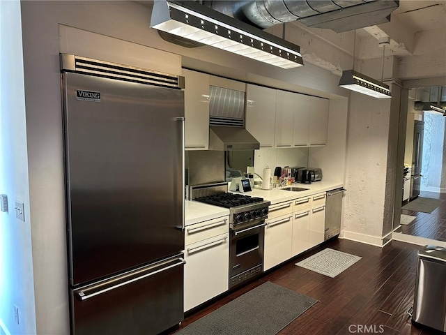 kitchen featuring extractor fan, dark wood-type flooring, white cabinetry, and high quality appliances