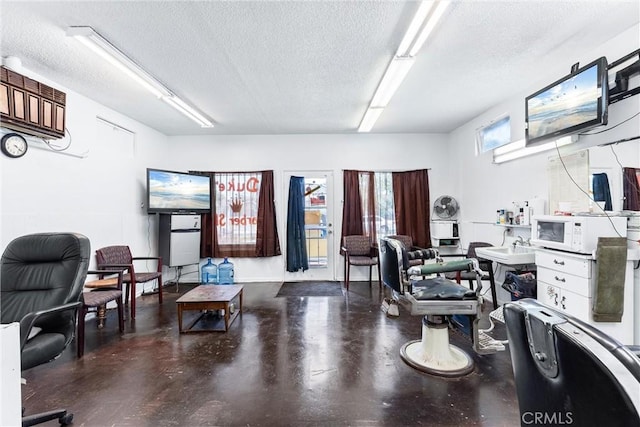 home office featuring a textured ceiling and concrete floors