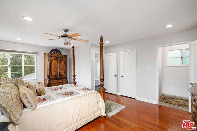 bedroom with hardwood / wood-style floors, ceiling fan, and multiple windows