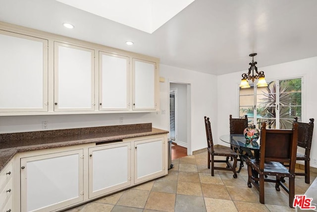 kitchen featuring decorative light fixtures, white cabinetry, and light tile floors