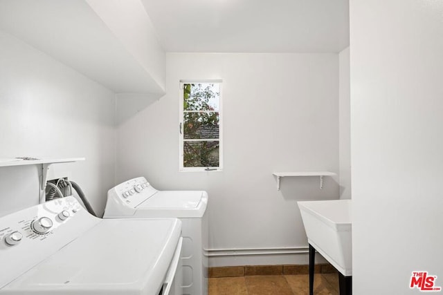 clothes washing area featuring sink, dark tile flooring, washer and clothes dryer, and hookup for a washing machine