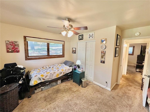 carpeted bedroom featuring ceiling fan and a closet