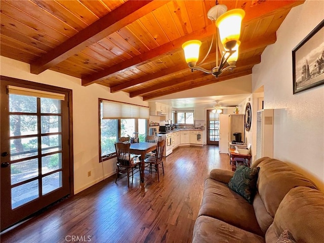 living room with ceiling fan with notable chandelier, lofted ceiling with beams, hardwood / wood-style flooring, and wood ceiling