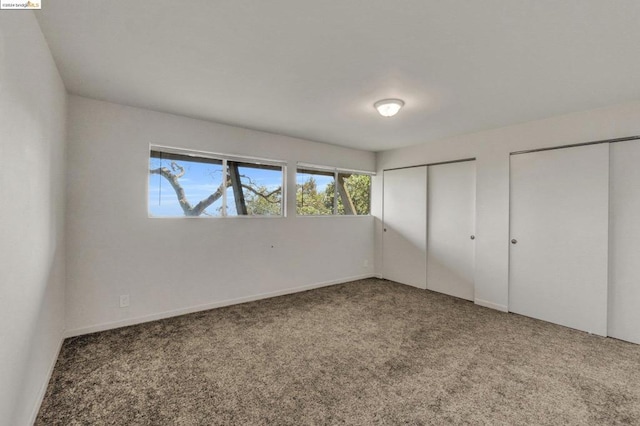 unfurnished bedroom with carpet and multiple closets