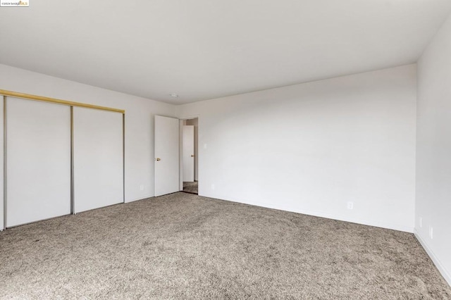 unfurnished bedroom featuring carpet and a closet