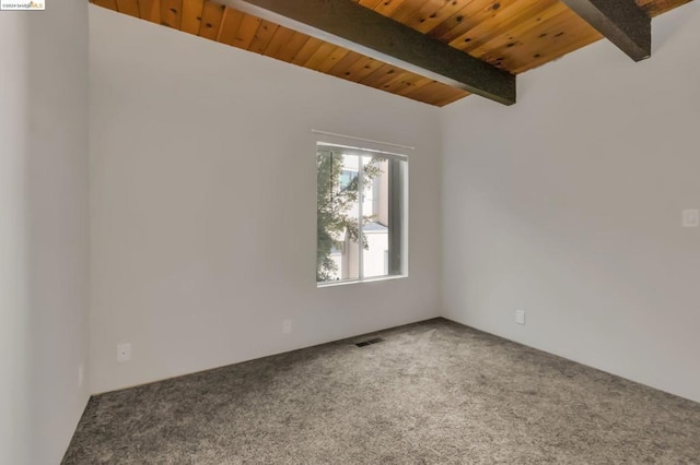 carpeted empty room featuring beam ceiling