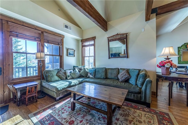 living room featuring vaulted ceiling with beams, a healthy amount of sunlight, and light hardwood / wood-style floors