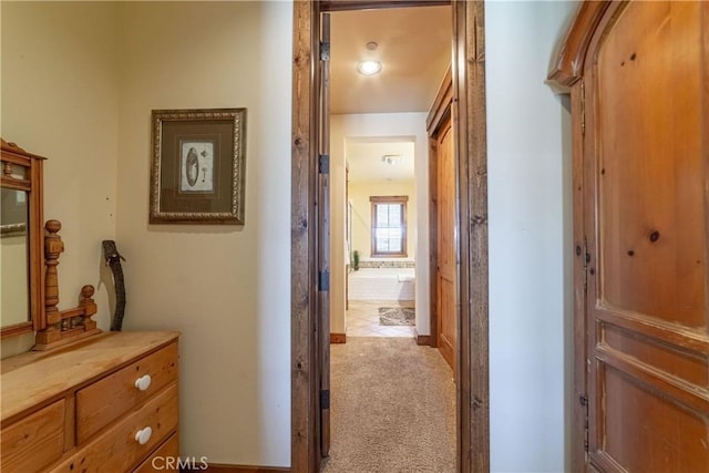 hall featuring light colored carpet