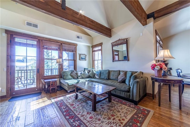 living room featuring hardwood / wood-style floors, plenty of natural light, beamed ceiling, and high vaulted ceiling