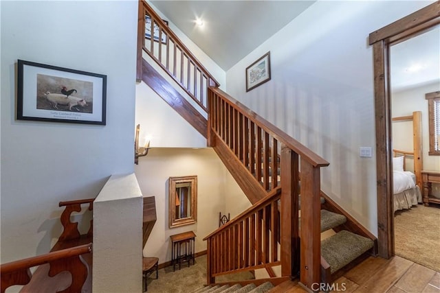 stairway featuring carpet and lofted ceiling