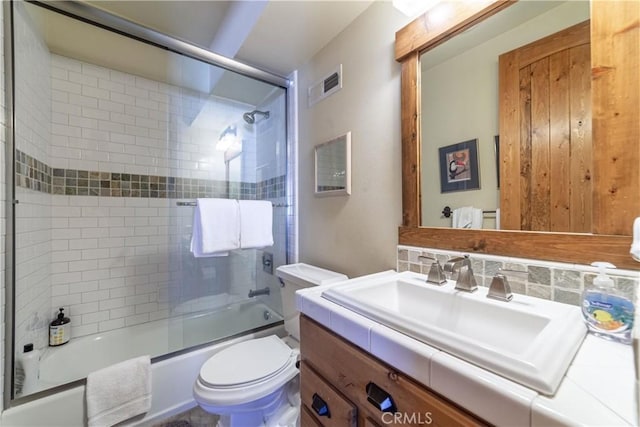 full bathroom featuring decorative backsplash, vanity, combined bath / shower with glass door, and toilet