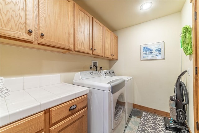 clothes washing area featuring tile patterned flooring, cabinets, and independent washer and dryer