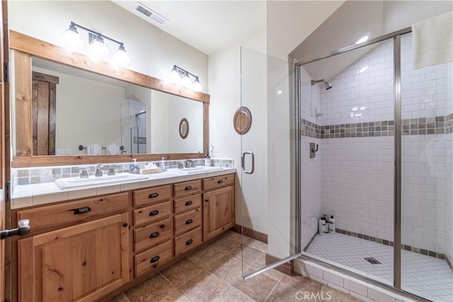 bathroom with tile patterned flooring, vanity, and a shower with door