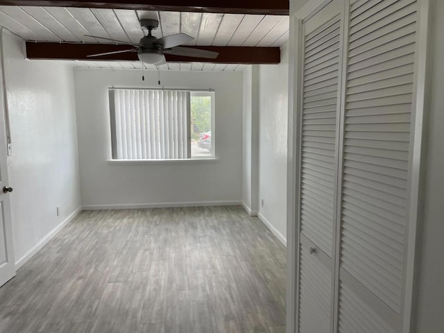 unfurnished bedroom with beam ceiling, ceiling fan, light hardwood / wood-style flooring, and wooden ceiling