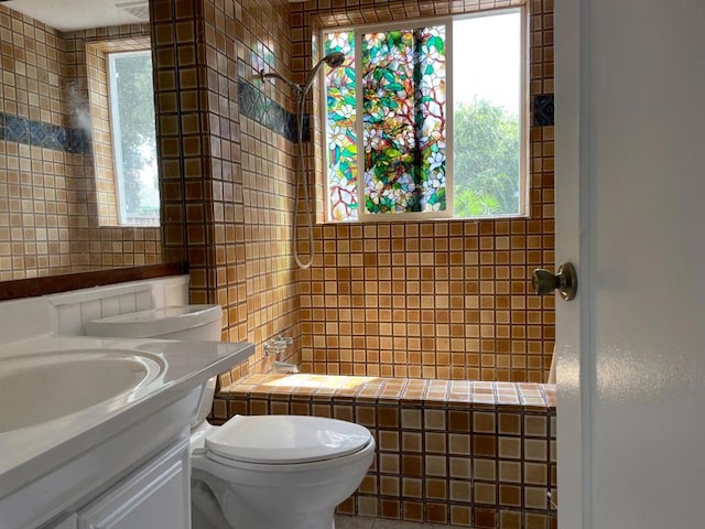 bathroom featuring a wealth of natural light, vanity, and toilet