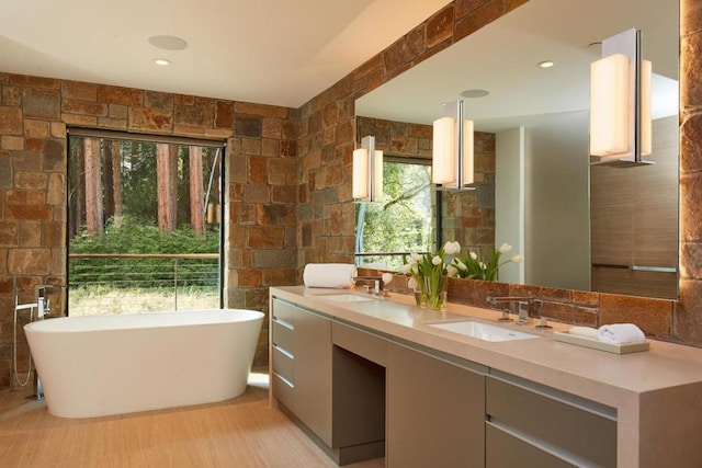 bathroom with vanity, tile walls, and a tub