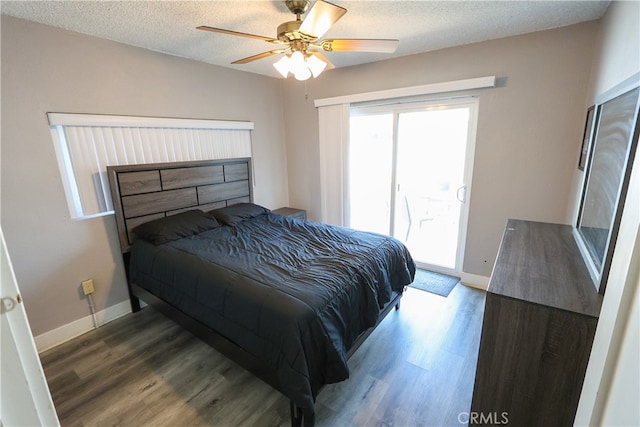 bedroom with ceiling fan, a textured ceiling, and dark wood-type flooring