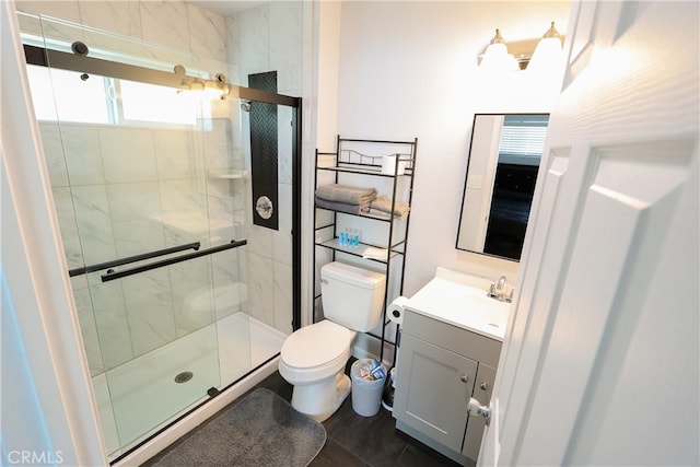 bathroom with vanity, a shower with shower door, toilet, and tile patterned flooring