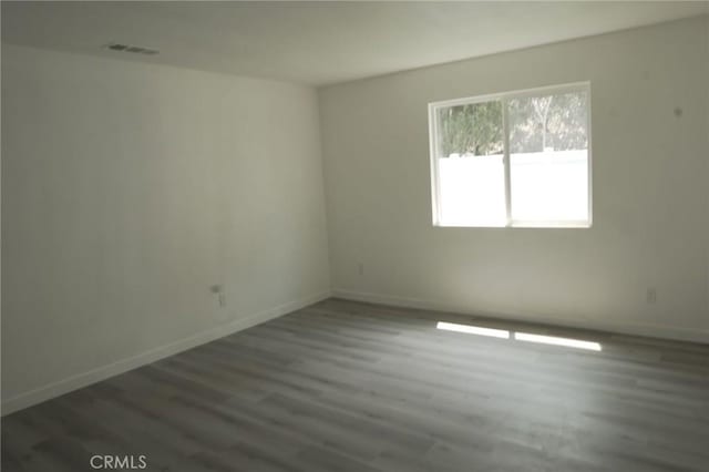 unfurnished room with dark wood-type flooring