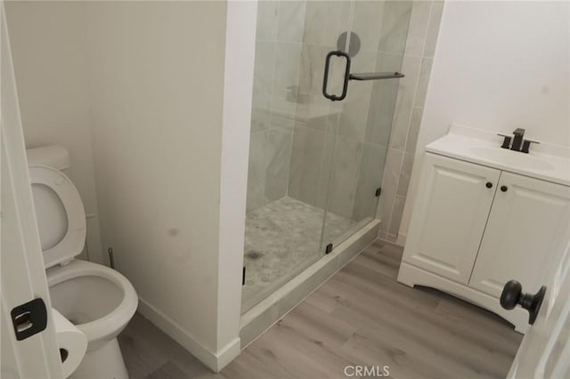 bathroom featuring vanity, hardwood / wood-style flooring, toilet, and an enclosed shower