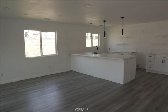 kitchen with white cabinets, decorative light fixtures, sink, and dark wood-type flooring