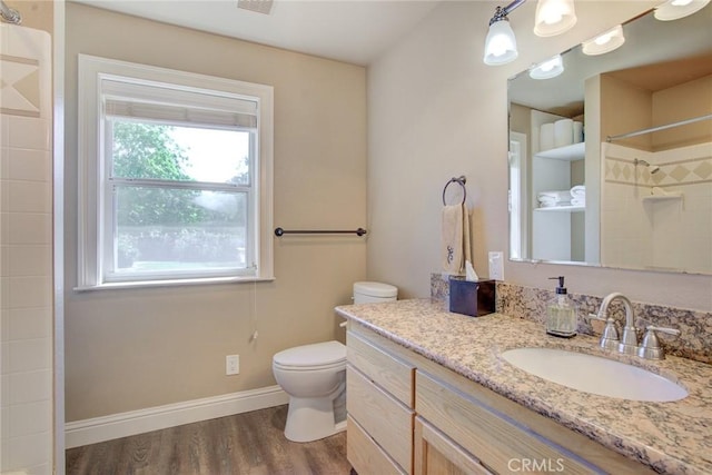 bathroom with vanity, toilet, hardwood / wood-style floors, and a shower