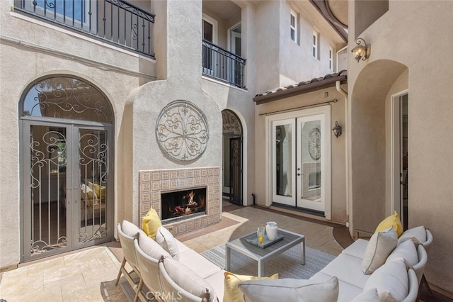 view of patio / terrace featuring a tile fireplace and french doors