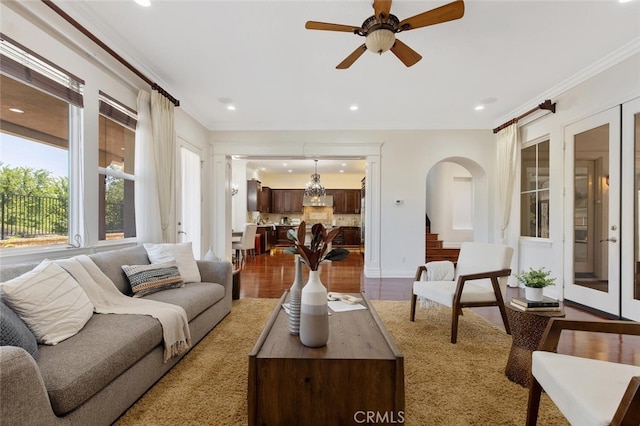 living room featuring hardwood / wood-style flooring, ceiling fan, and ornamental molding