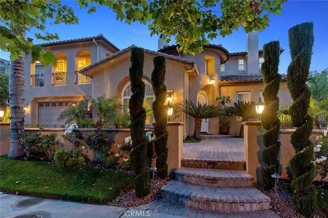 mediterranean / spanish-style house with a garage and a balcony