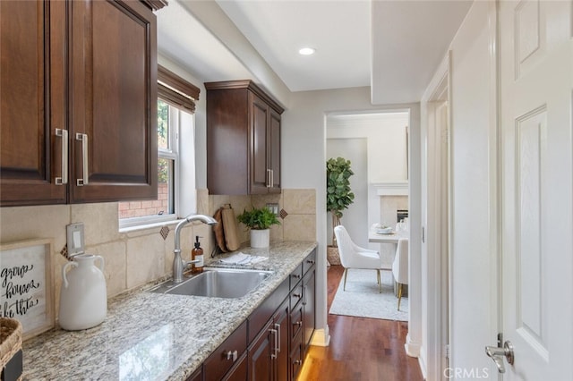 kitchen featuring tasteful backsplash, dark brown cabinetry, and sink