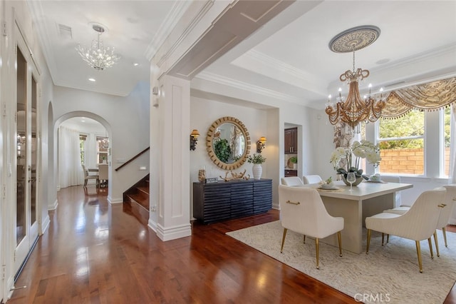 dining room featuring crown molding, dark hardwood / wood-style floors, a raised ceiling, and a notable chandelier