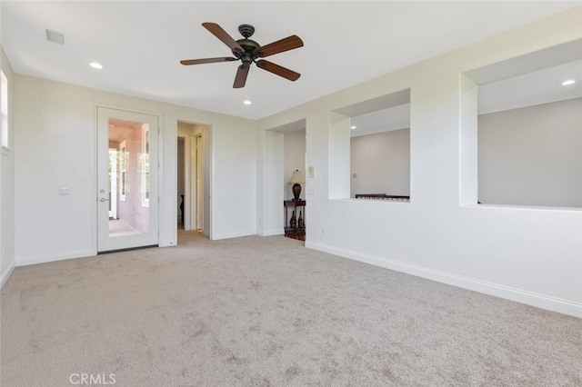 spare room featuring ceiling fan and light carpet