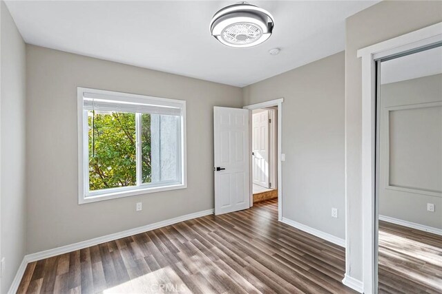 unfurnished bedroom with dark wood-type flooring