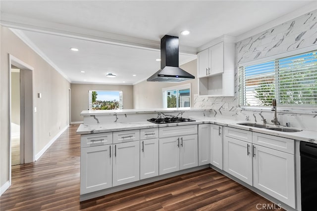 kitchen with wall chimney range hood, dark wood-type flooring, kitchen peninsula, stainless steel gas cooktop, and sink