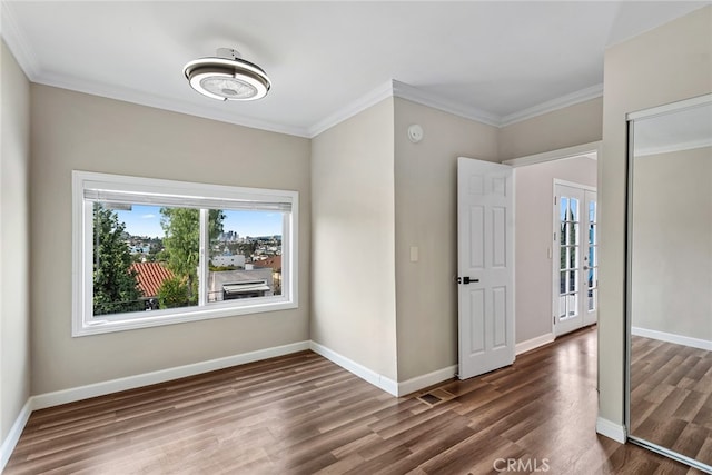 spare room with ornamental molding and dark hardwood / wood-style flooring