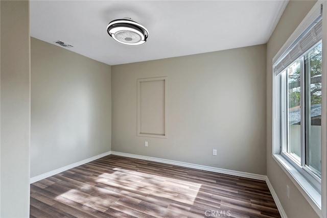 unfurnished room featuring dark hardwood / wood-style floors and plenty of natural light