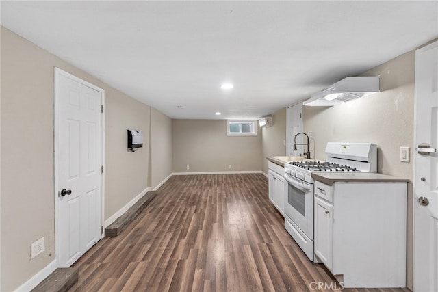 kitchen featuring white cabinets, sink, white gas stove, and dark hardwood / wood-style floors